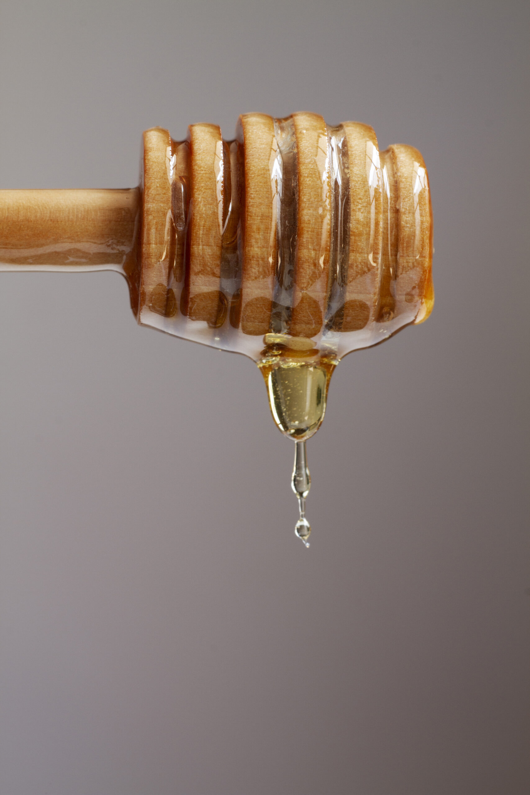 front-view-wooden-honey-dipper-with-honey